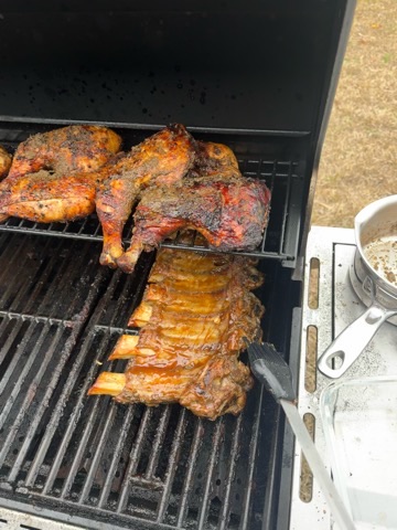 Chicken and ribs cooking together on the grill