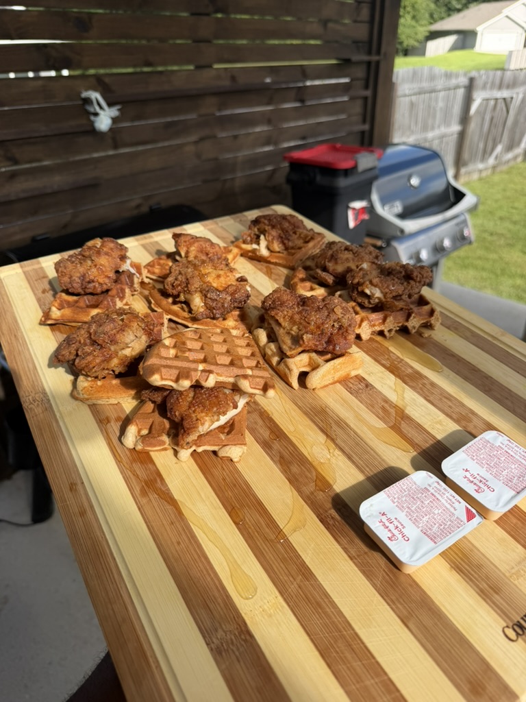 Fried chicken and waffles on a wooden serving board